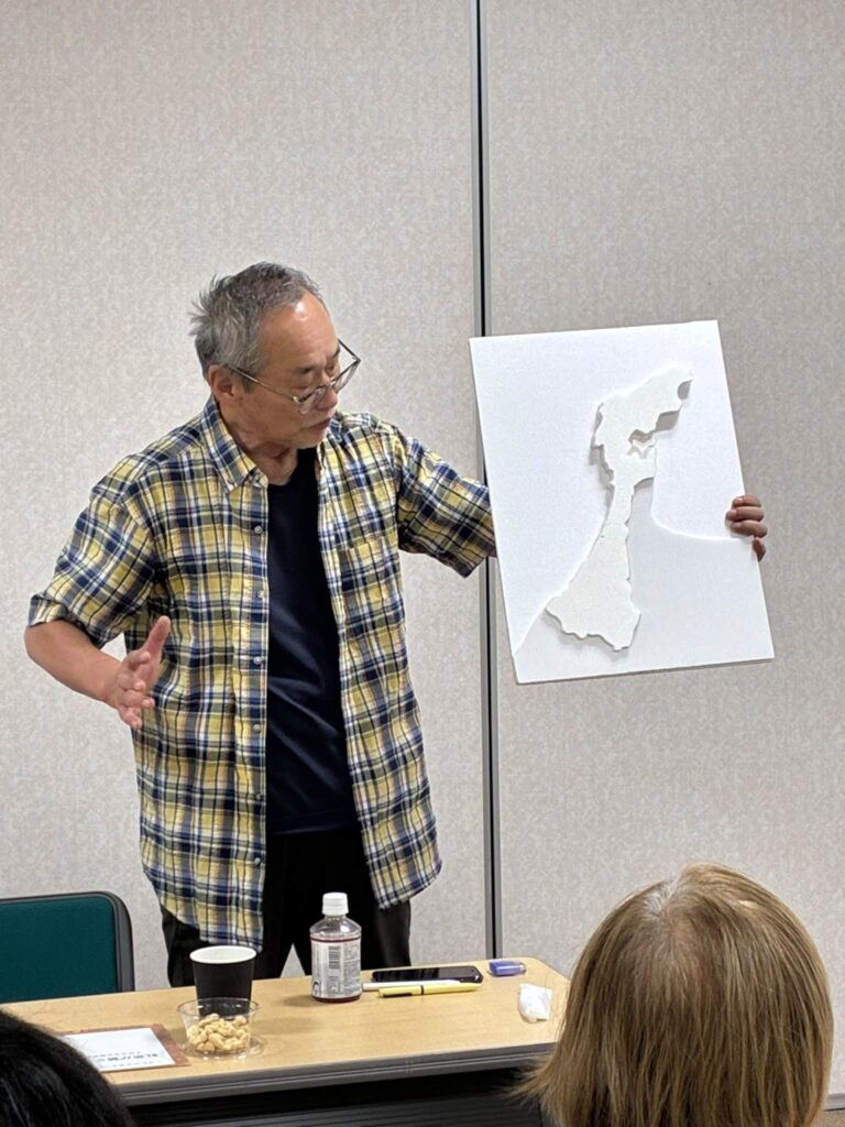仲山さんが　石川県の立体地図を持ってお話ししてる